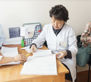 Healthcare worker in Tajikistan reviewing vaccination and health records as part of public health preparedness efforts