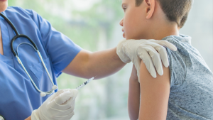 Healthcare provider preparing to administer an influenza vaccine to a child during a medical visit.
