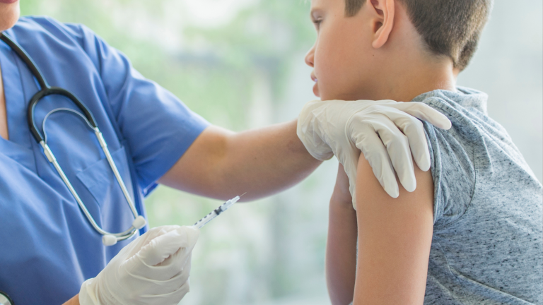 Healthcare provider preparing to administer an influenza vaccine to a child during a medical visit.